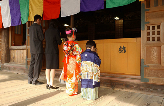 七五三の御参りをする家族