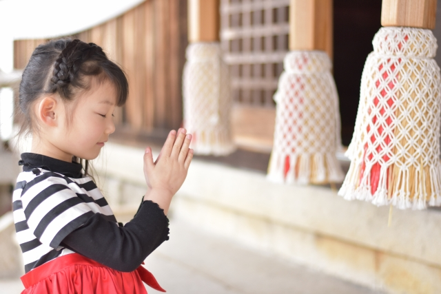 神社で参拝する女の子